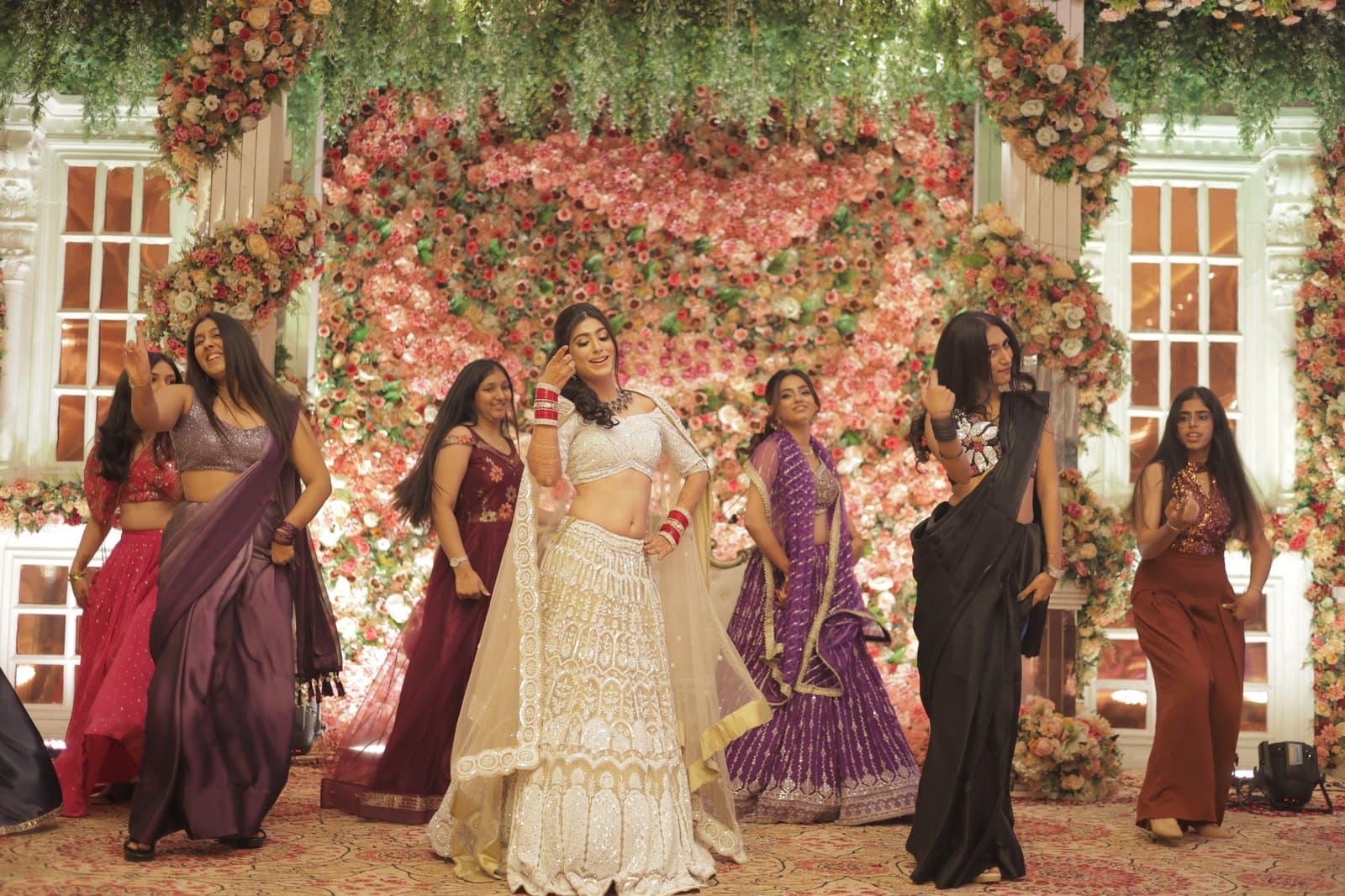 The bride and her party under a floral arch after their performance