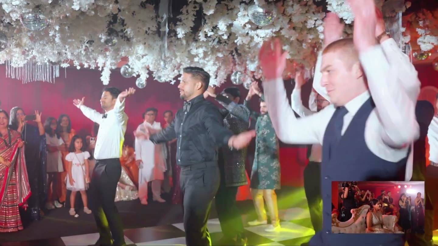 The groom dancing with a groomsman while family watch from the edge of the floor